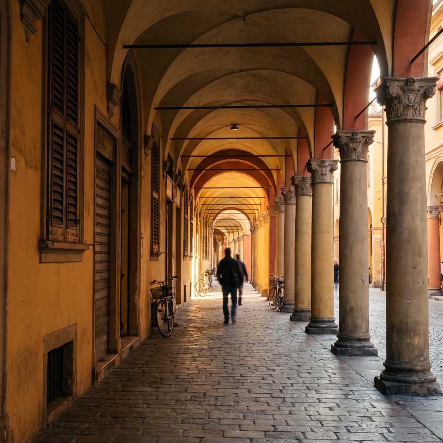 Galleria di portici voltati di un centro storico italiano, nella luce del tardo pomeriggio