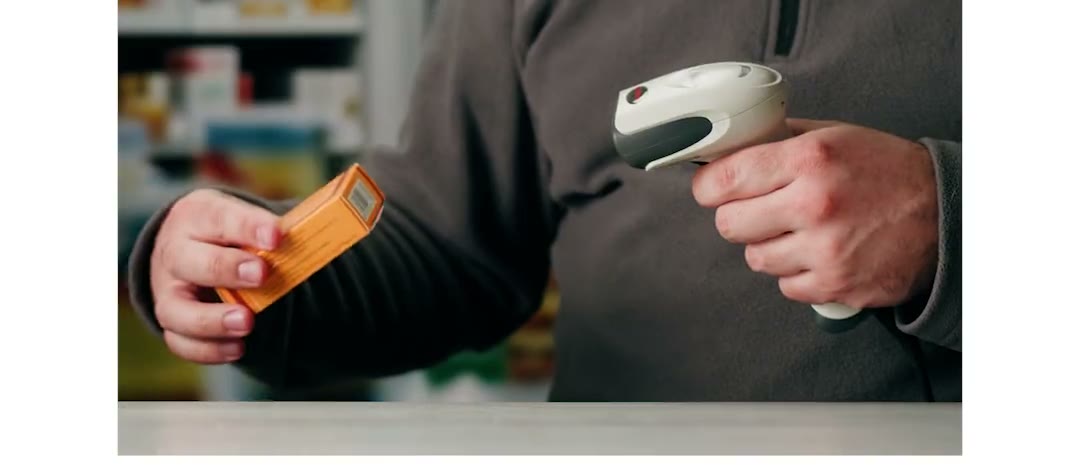 Un farmacista scansiona una confezione al banco, video in loop del cockpit Nexum Pro